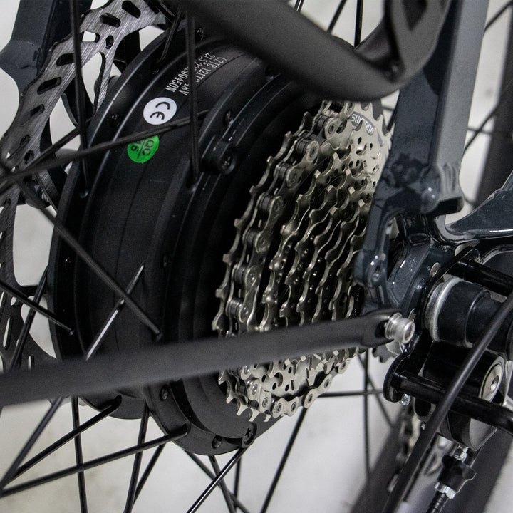 ultra close up of view of 9 speed Shimano derailleur gear system and hub of Eunorau Meta275 500W Electric Cruiser Bike with Torque Sensor for Commuters
